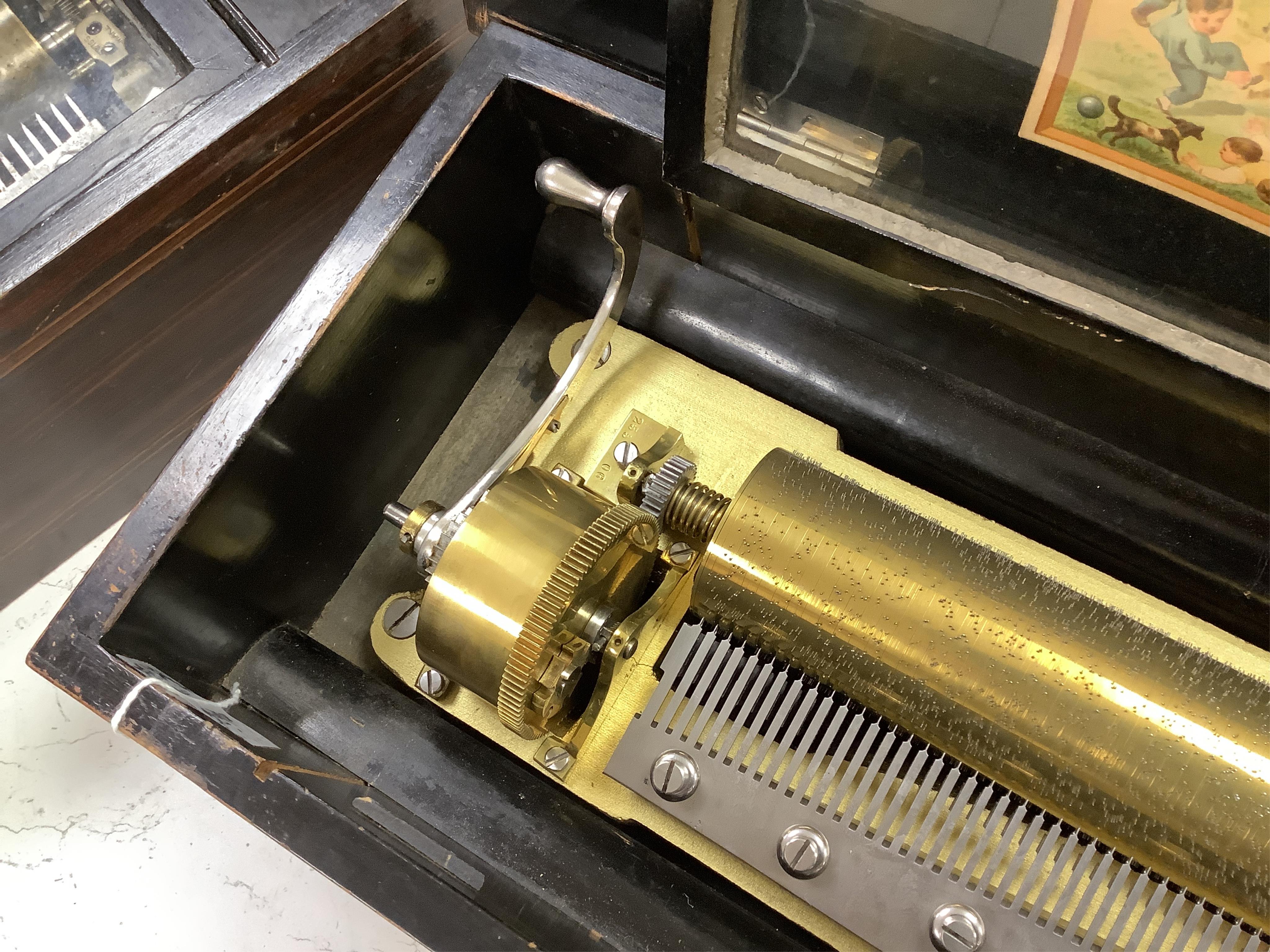 A late 19th century Swiss rosewood ten air cylinder music box, with inlaid lid decorated with musical instruments and foliage, paper label listing the airs to inside of lid, with sixty two tooth comb, cylinder 28cm, case